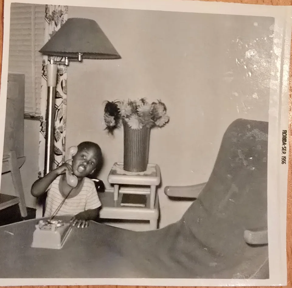 Keith as a child holding a telephone receiver
